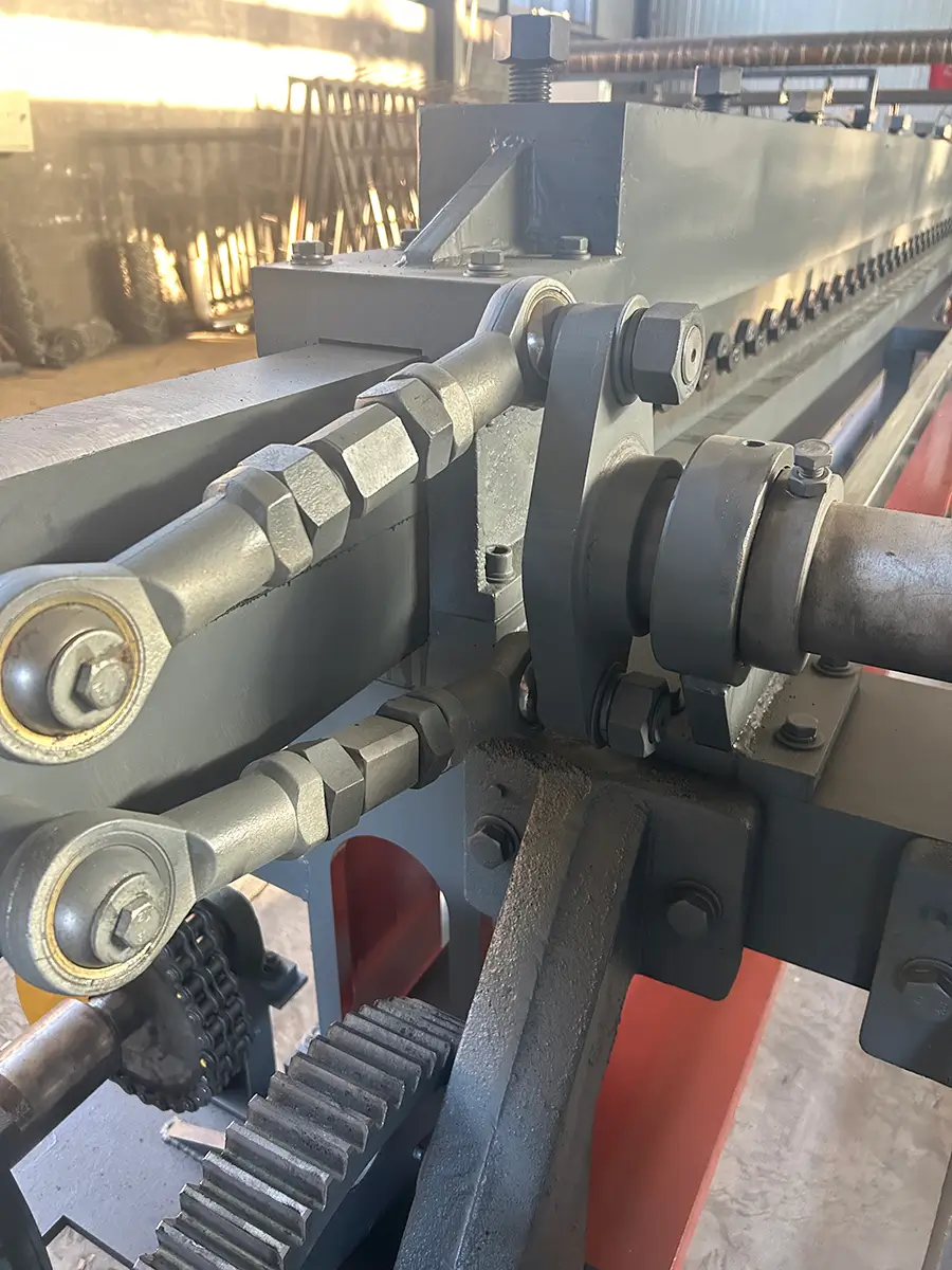 Close-up of the core twisting mechanism showing two spherical rod ends (fish-eye linkages) driving the upper and lower twisting plates to form hexagonal mesh openings.
