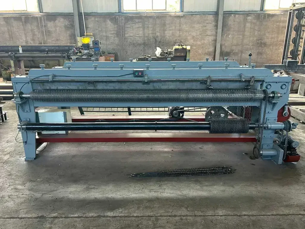 Front view of the YOUTE small hexagonal wire mesh machine showing the weaving area and finished hexagonal mesh panel output