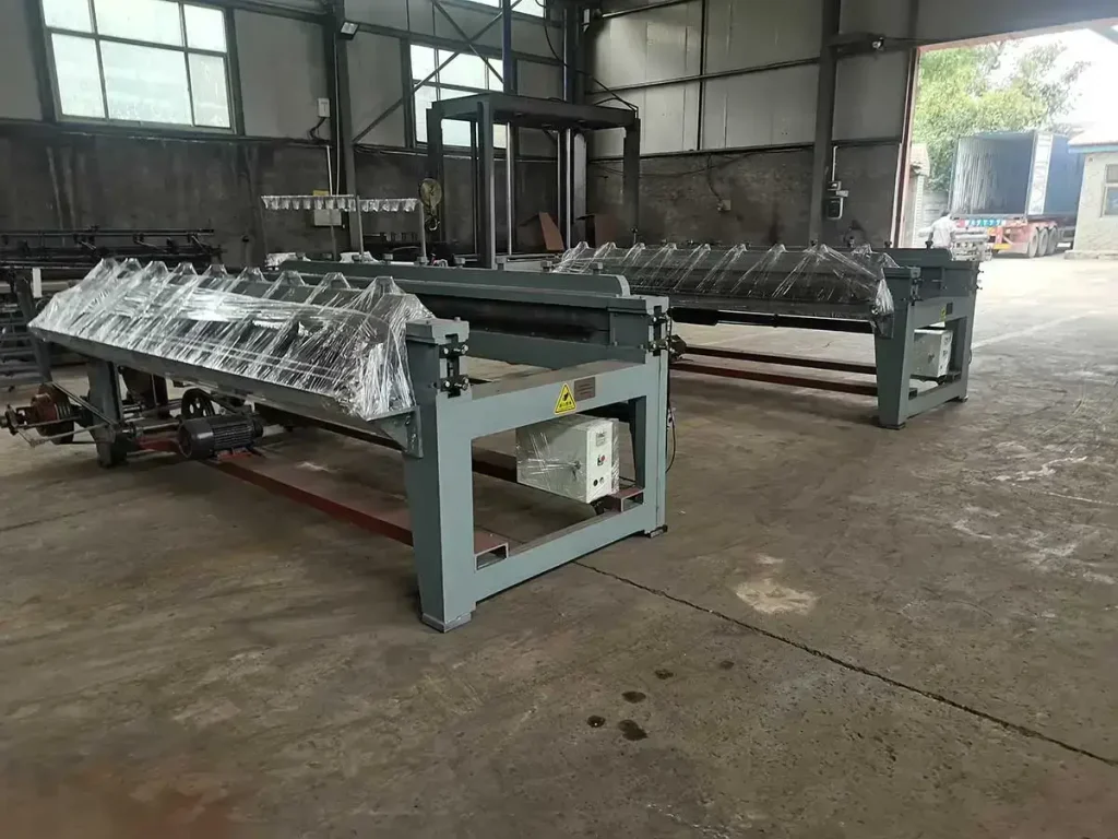 Two small hexagonal wire mesh machines wrapped in protective stretch film, ready for shipment in the workshop.